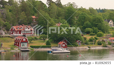 Many Red Swedish Wooden Sauna Logs Cabins Houses On Island Coast In Summer Cloudy Day 81092655