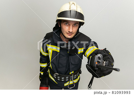 One male firefighter dressed in uniform posing over white studio background. 81093993