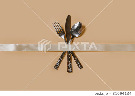 A set of cutlery - fork, spoon and knife. Top view. Pastel background A set of cutlery - fork, spoon and knife. Top view. Pastel background 81094134