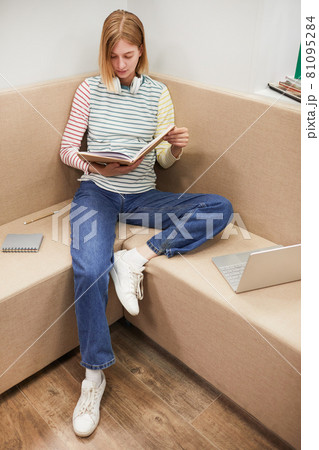 Young Woman Reading Book in College 81095284