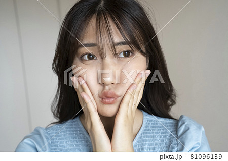 頬を押さえる女性 81096139