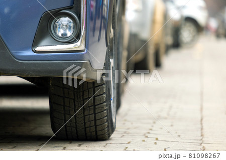 Closeup of parked car on a city street side with new winter rubber tires. 81098267