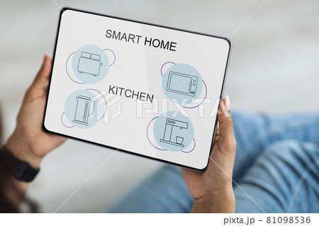 African american woman controlling kitchen devices, using digital tablet African american woman controlling kitchen devices, using digital tablet 81098536
