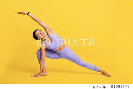 Wellness concept. Fit black woman standing in yoga pose on yellow studio background, full length portrait, free space 81098575
