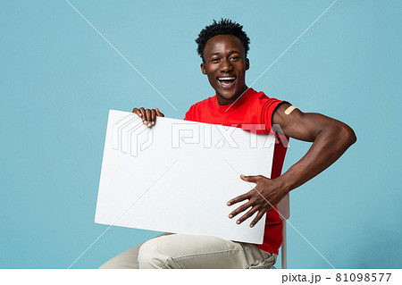 Cheerful Vaccinated Black Guy With Plaster On Arm Holding Blank Placard 81098577