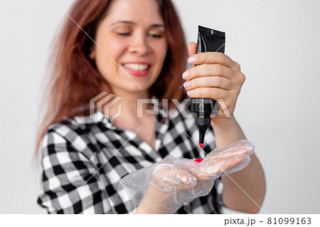 Close-up of young woman dyes her hair at home. Bright hair coloring concept. Close-up of young woman dyes her hair at home. Bright hair coloring concept. 81099163