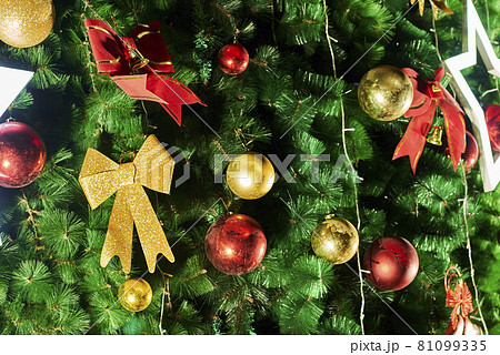 Festive Christmas tree background with decorations. Merry Christmas background. Closeup shot of Christmas tree with Xmas decorations Festive Christmas tree background with decorations. Merry Christmas background. Closeup shot of Christmas tree with Xmas decorations 81099335
