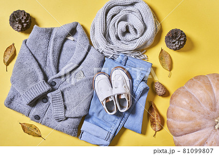 Baby autumn wear clothes on yellow background. Top view. Overhead view of warm kid autumn clothes on colored backdrop 81099807