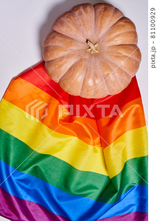 LGBTQ rainbow flag and big orange pumpkin. Halloween pumpkin with rainbow LGBT flag 81100929