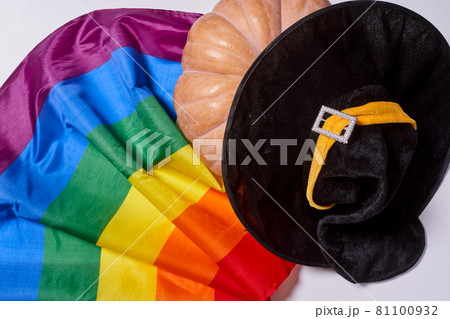 LGBTQ rainbow flag and big orange pumpkin. Halloween pumpkin with rainbow LGBT flag and black witch hat 81100932
