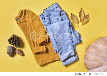Baby autumn wear clothes on yellow background. Top view. Overhead view of warm kid autumn clothes on colored backdrop Baby autumn wear clothes on yellow background. Top view. Overhead view of warm kid autumn clothes on colored backdrop 81100942