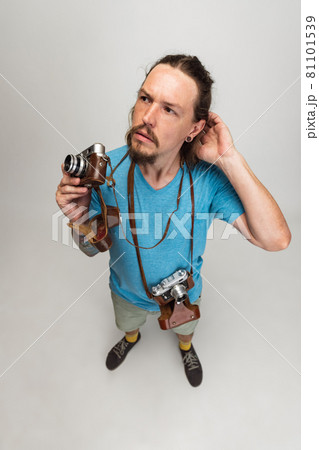 High angle view of young man, photographer, cameraman with retro camera isolated on gray studio background. Concept of occupation, job, funny meme emotions High angle view of young man, photographer, cameraman with retro camera isolated on gray studio background. Concept of occupation, job, funny meme emotions 81101539