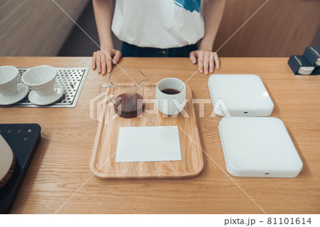 Female barista standing behind counter in coffee shop Female barista standing behind counter in coffee shop 81101614