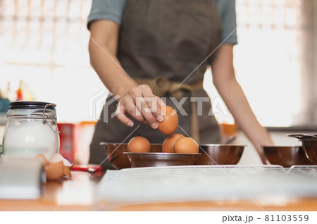 Woman chef pick up fresh raw egg preparing ingredient for making healthy cuisine. 81103559