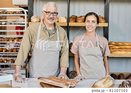 Successful bakers in workwear standing by workplace Successful bakers in workwear standing by workplace 81107103
