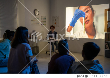 Youthful schoolkids watching video about scientific experiment 81107578