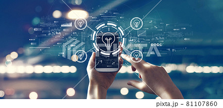 Light bulbs theme with person using smartphone 81107860