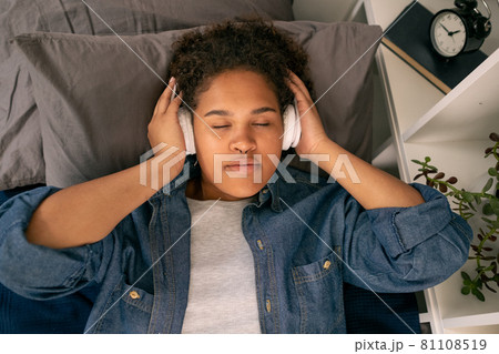Teenage girl listening to relaxation music before sleep Teenage girl listening to relaxation music before sleep 81108519