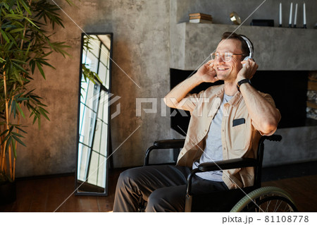 Happy Man in Wheelchair Enjoying Music 81108778