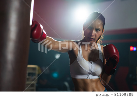 Young Asian doing boxing or Muay Thai punching sandbag in fitness club or gym. healthcare and sport concept. Young Asian doing boxing or Muay Thai punching sandbag in fitness club or gym. healthcare and sport concept. 81109289