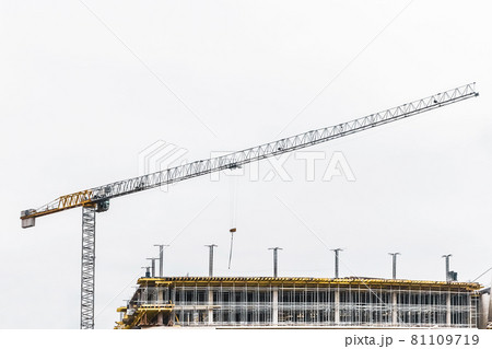Industrial tower crane builds new concrete city building or apartments on construction site 81109719