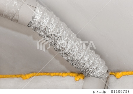 Ventilation air metal pipe under ceiling with construction polyurethane foam insulation at an industrial plant or factory 81109733