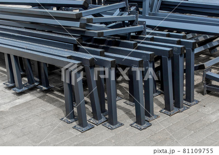 Pile of new metal structures or steel industrial material on paving slabs sidewalk at construction site Pile of new metal structures or steel industrial material on paving slabs sidewalk at construction site 81109755