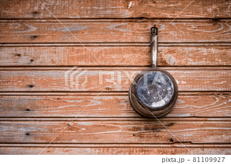 old aluminum ladle lies on a wooden board 81109927