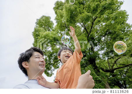 公園でシャボン玉で遊ぶ男の子と父親 公園でシャボン玉で遊ぶ男の子と父親 81113626