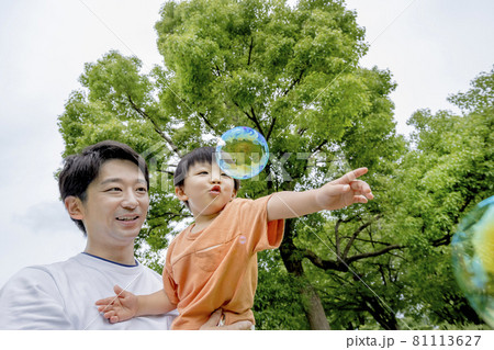 公園でシャボン玉で遊ぶ男の子と父親 公園でシャボン玉で遊ぶ男の子と父親 81113627