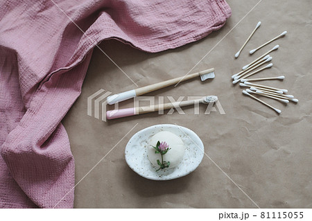 Soap bar or solid shampoo on a soap dish, bamboo toothbrush and towel top view with copyspace. Accessories for personal hygiene. Plastic free and eco friendly products in household 81115055