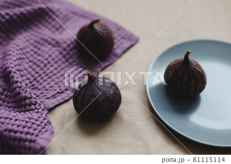 ripe fresh figs and purple textiles on rustic background, flatlay, overhead view 81115114
