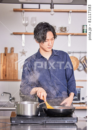 キッチンで料理するエプロン姿の若い男性　料理男子イメージ 81117383