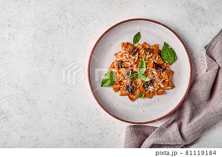 Farfalle with eggplant, tomato sauce and basil on plate with napkin 81119184