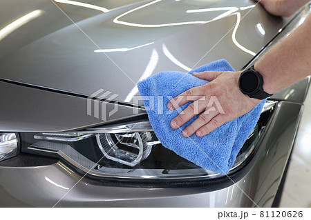 Man hand cleaning car and drying vehicle with microfiber cloth closeup Man hand cleaning car and drying vehicle with microfiber cloth closeup 81120626