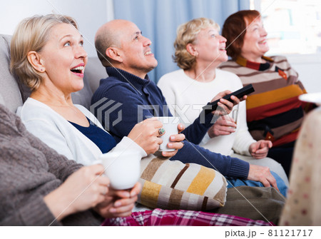 Mature women and man are watching TV Mature women and man are watching TV 81121717
