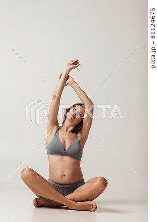 Portrait of pregnant sportive woman in lingerie isolated over grey studio background. Natural beauty, happy motherhood, femininity concept. Portrait of pregnant sportive woman in lingerie isolated over grey studio background. Natural beauty, happy motherhood, femininity concept. 81124675
