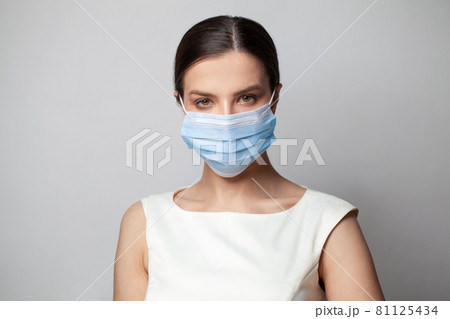 Young woman wearing a medical face mask 81125434