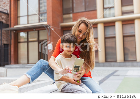 Two people, mother and little cute son strolling at street, trade square in summer time, outdoors. Family time, togehterness, parenting and happy childhood concept. Two people, mother and little cute son strolling at street, trade square in summer time, outdoors. Family time, togehterness, parenting and happy childhood concept. 81126136