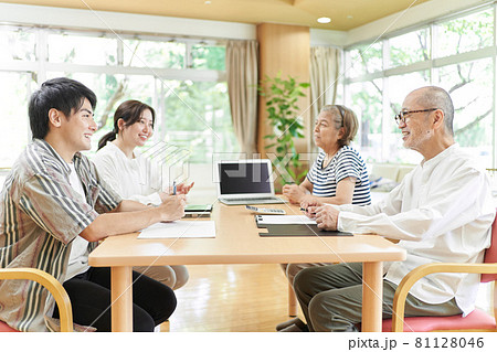 笑顔で会話する若夫婦と老夫婦 81128046