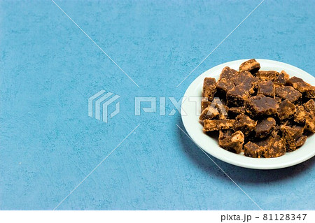 コピースペースのある白い皿に盛られた黒砂糖 81128347