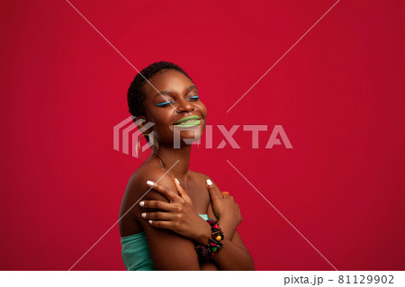 Exotic afro american young woman posing on red, panorama Exotic afro american young woman posing on red, panorama 81129902