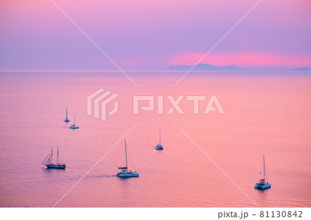 Tourist yachts boat in Aegean sea near Santorini island with tourists watching sunset viewpoint. Santorini, Greece Tourist yachts boat in Aegean sea near Santorini island with tourists watching sunset viewpoint. Santorini, Greece 81130842