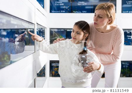 Cute girl with her mother customer buying tropical fish Cute girl with her mother customer buying tropical fish 81131549