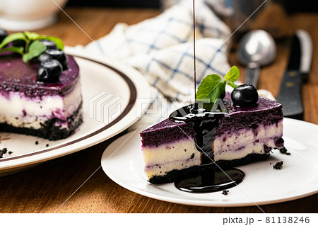 Pouring chocolate on a piece of delicious homemade blueberry cheesecake. 81138246