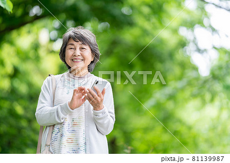 スマホを操作するシニア女性 屋外でスマホを触るお婆さん スマホを操作するシニア女性 屋外でスマホを触るお婆さん 81139987