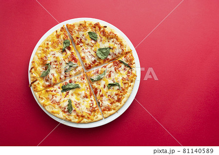 Classic cheese pizza over colourful red background with copy space. Fast food. Classic cheese pizza over colourful red background with copy space. Fast food. 81140589