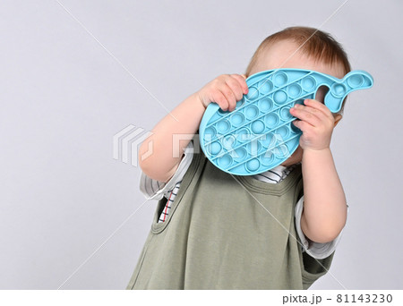 Curious little boy using toy pop it isolated on Curious little boy using toy pop it isolated on 81143230