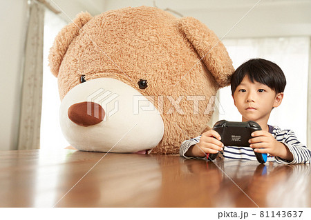 クマと並んでゲームを楽しむ男の子 クマと並んでゲームを楽しむ男の子 81143637