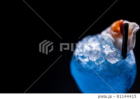 luxury blue alcohol cocktail decorated with shrimp in glass on black background luxury blue alcohol cocktail decorated with shrimp in glass on black background 81144415